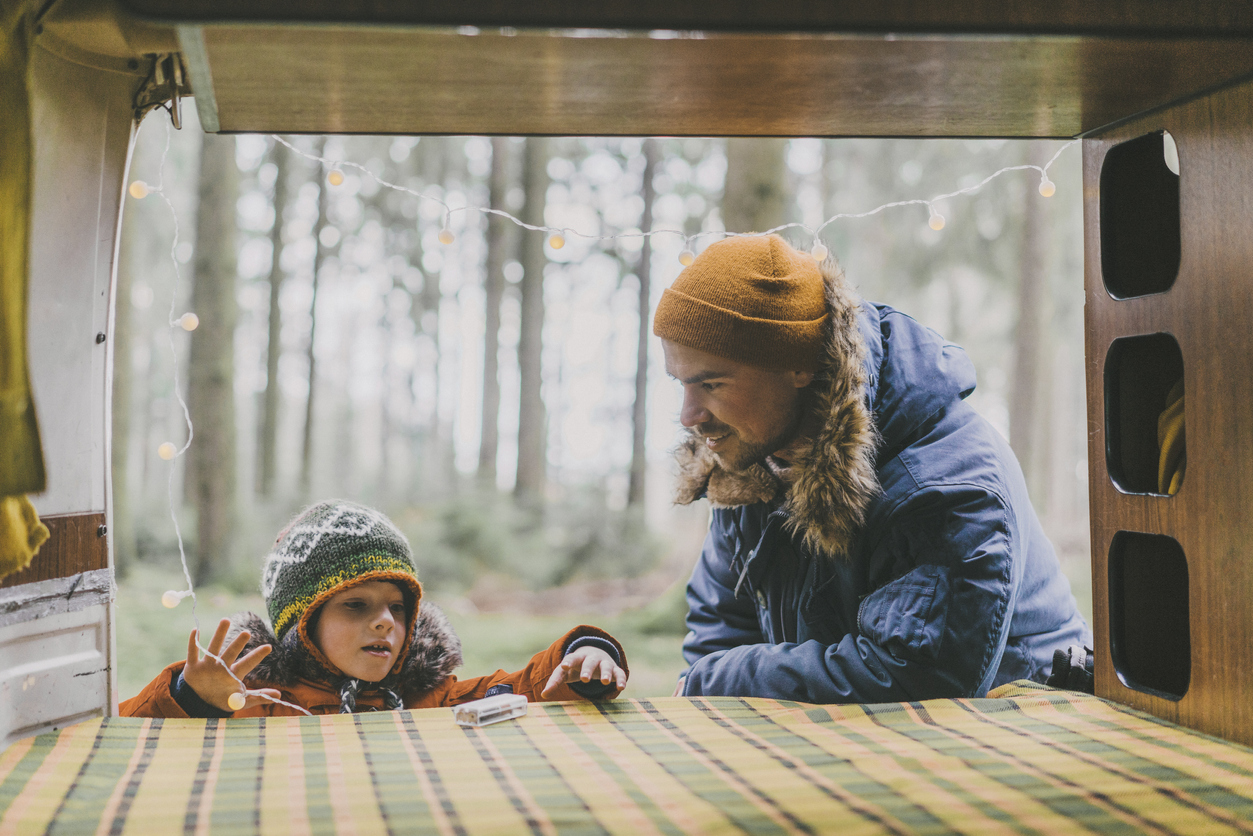 Caucasian father with son placing lights in camper van