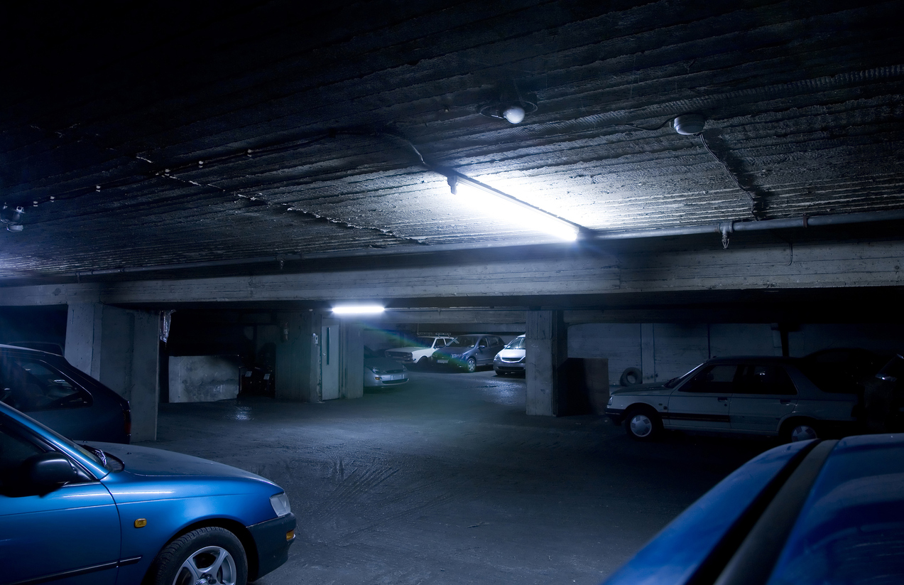 View of an old underground parking area with parked cars.